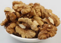 dried brownish walnut kernsl are piled in a plate